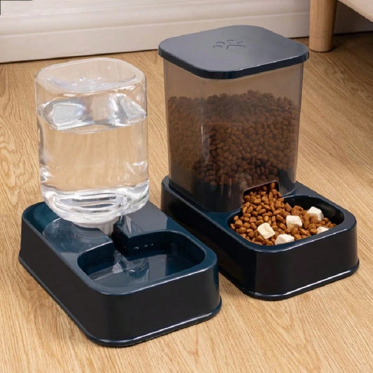 Automatic pet feeder setup with water dispenser and dry food container on dark bases, placed on wooden floor for continuous pet nourishment.